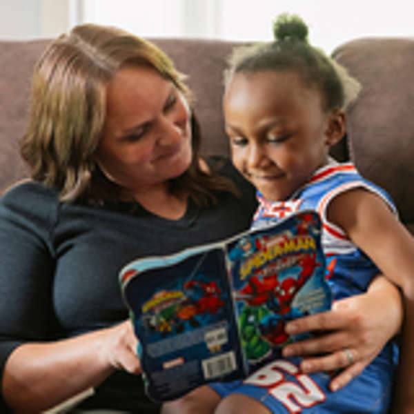 A Safe Families for Children volunteer reads a book to a young child